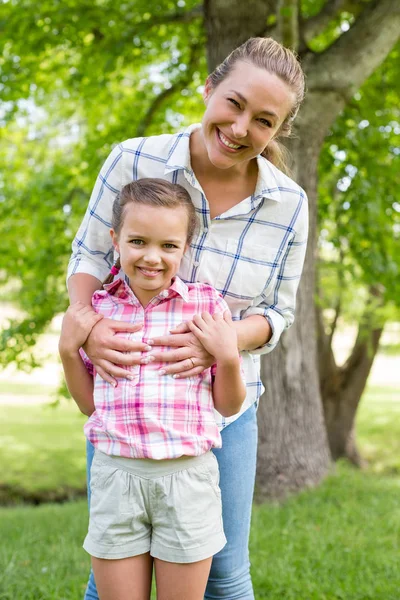 Mother embracing her daughter in park — Stock Photo, Image