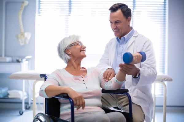 Fisioterapeuta auxiliando o paciente idoso com exercício manual — Fotografia de Stock