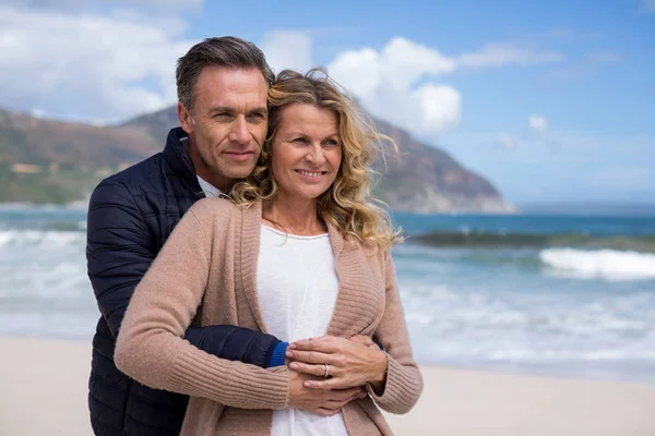 Ouder paar omhelzen elkaar op het strand — Stockfoto