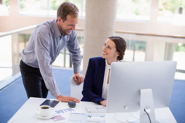 Businesswoman working at desk with colleague — Stock Photo, Image