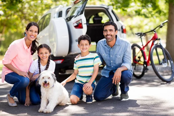 Família feliz desfrutando junto com seu cão de estimação no parque — Fotografia de Stock