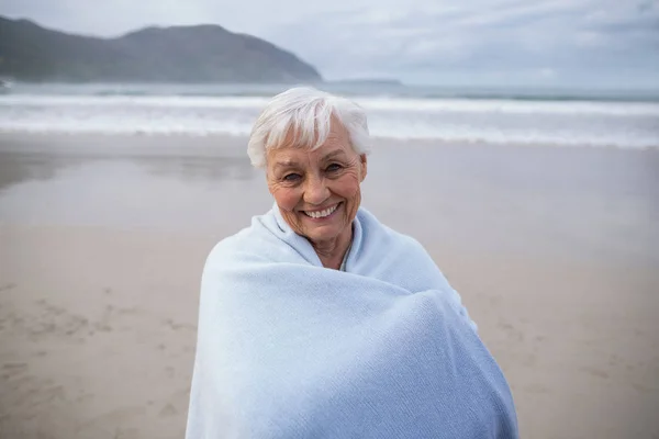 Retrato de una mujer mayor de pie en la playa — Foto de Stock