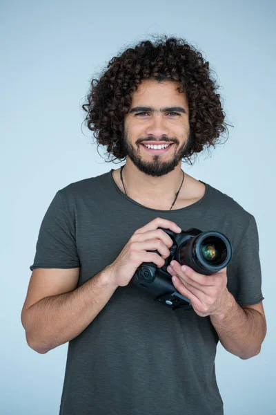 Fotógrafo segurando uma câmera no estúdio — Fotografia de Stock