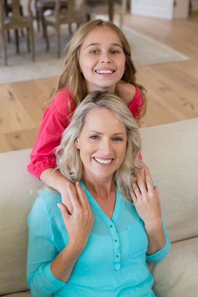 Retrato de madre e hija sonriendo en la sala de estar — Foto de Stock