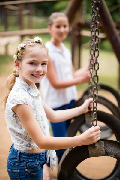Gelukkig meisje lacht terwijl een schommel in park — Stockfoto