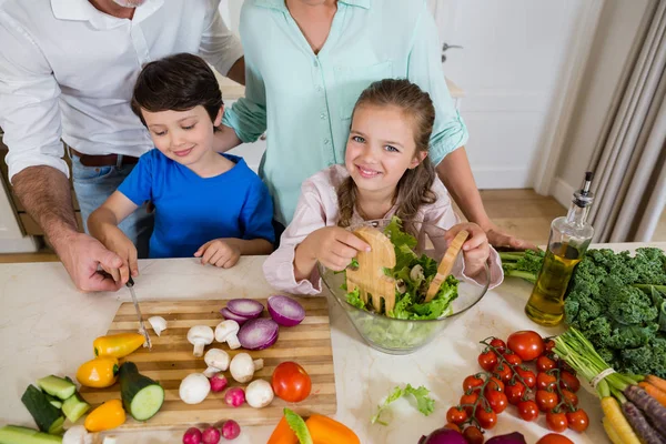 子供と親は台所で野菜サラダを準備します。 — ストック写真