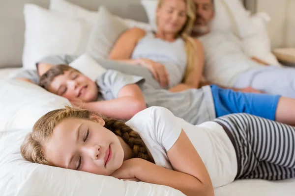 Föräldrar och barn sover på sängen i sovrummet — Stockfoto