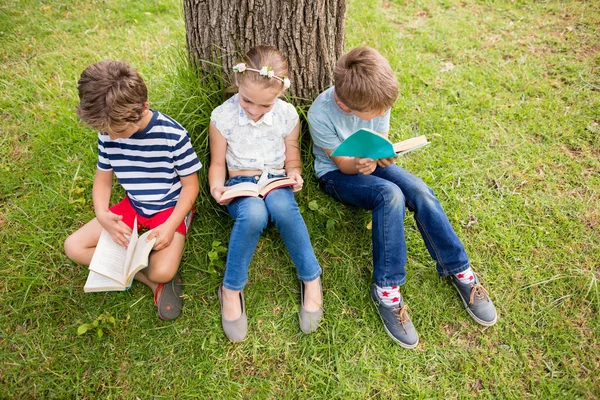 Kids reading book in park — Stock Photo, Image