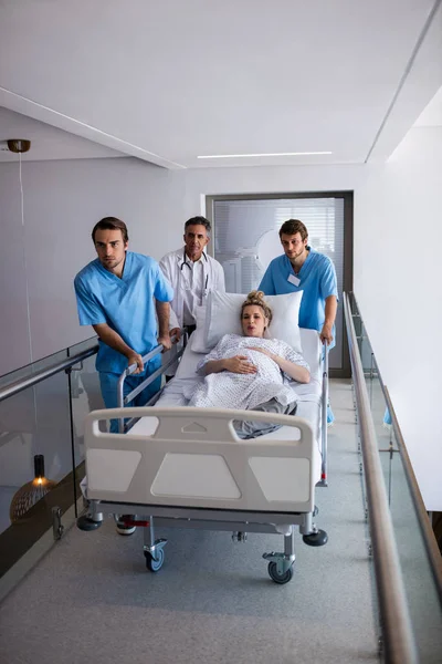 Team of doctors taking a pregnant woman to operation theatre — Stock Photo, Image