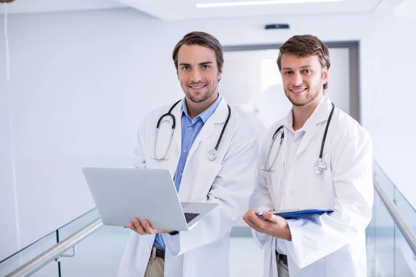 Ritratto di medici che utilizzano laptop in corridoio — Foto Stock