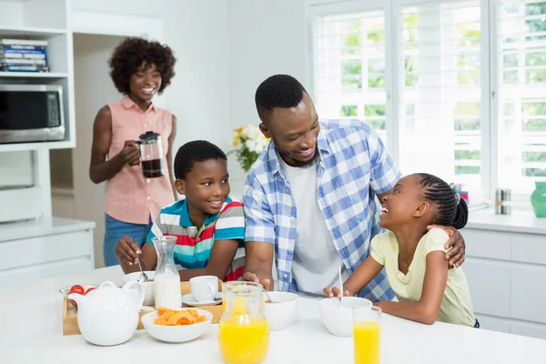 Děti a rodiče mají snídani na stole doma — Stock fotografie