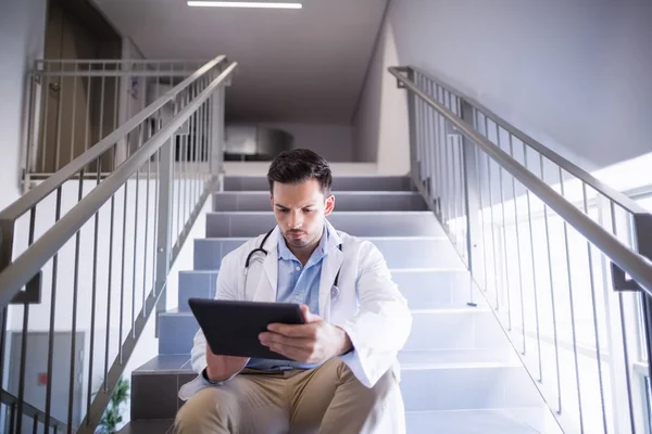 Ο γιατρός κάθεται στο κλιμακοστάσιο χρησιμοποιώντας ψηφιακό tablet — Φωτογραφία Αρχείου