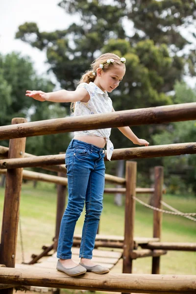 Dívka hraje na projížďku hřiště v parku — Stock fotografie