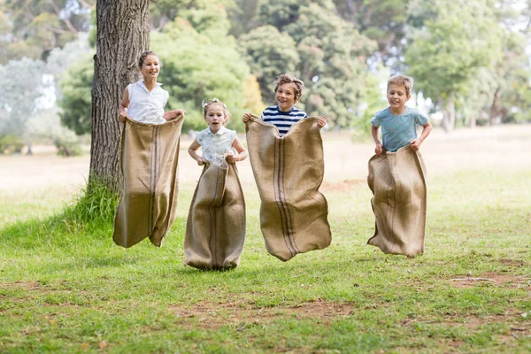 Kids having a sack race in park — Stock Photo, Image