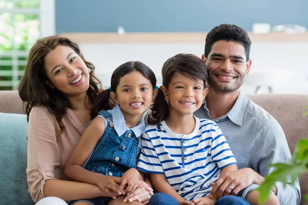 Portrait of happy parents and kids sitting on sofa in living room — Stock Photo, Image