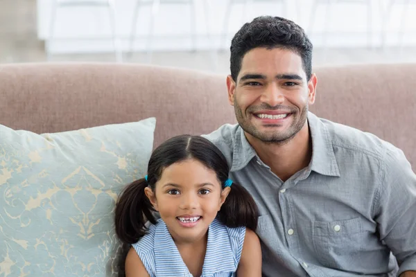 Портрет счастливого отца и дочери, сидящих на диване в гостиной — стоковое фото
