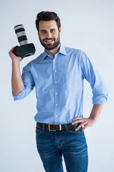 Fotograf, trzymając aparat w studio — Zdjęcie stockowe