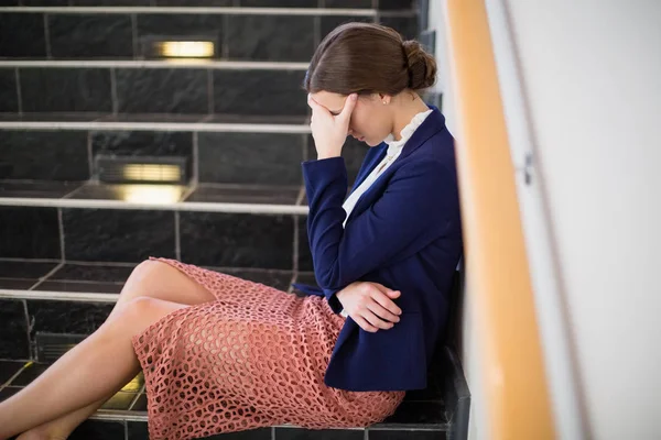 Беспокойная деловая женщина сидит на ступеньках — стоковое фото
