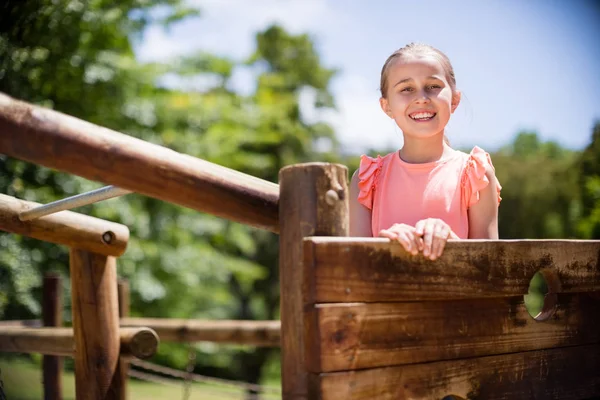 Κορίτσι στέκεται και χαμογελαστός για βόλτα στο πάρκο με παιδική χαρά — Φωτογραφία Αρχείου