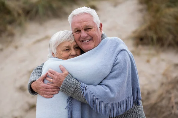 年长的夫妇裹围巾在海滩上 — 图库照片