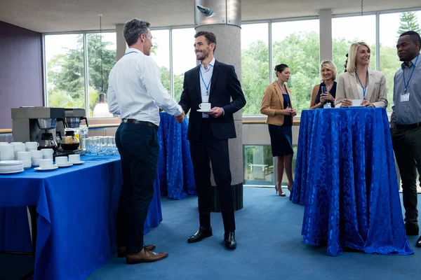 Företagsledare som interagerar med varandra med kopp kaffe — Stockfoto