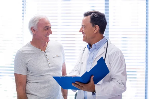 Médico y hombre mayor sonriendo mientras tienen discusión en el archivo —  Fotos de Stock