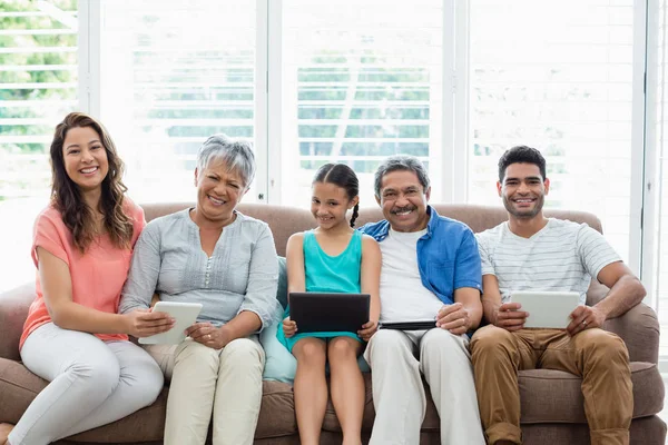 Familia multigeneración que utiliza tableta digital en la sala de estar en casa — Foto de Stock