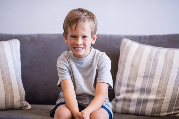 Retrato de menino sorridente sentado no sofá — Fotografia de Stock
