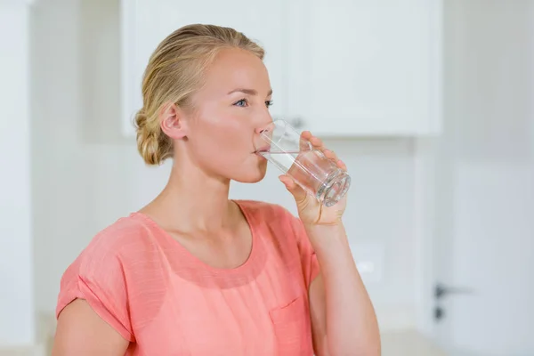Wody pitnej kobieta od szkło w kuchni — Zdjęcie stockowe