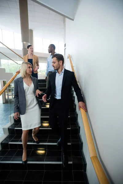 Business executives walking down the stairs — Stock Photo, Image