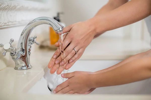 Moeder en dochter wassen, handen in de badkamer wastafel — Stockfoto