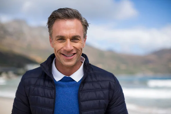 Sorridente uomo maturo in piedi sulla spiaggia — Foto Stock
