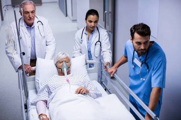 Médico y enfermera empujando camilla de emergencia en el pasillo —  Fotos de Stock