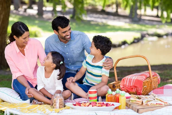 Счастливая семья завтракает в парке — стоковое фото