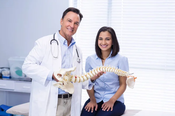 物理治疗师和病人掌握脊柱模型的肖像 — 图库照片