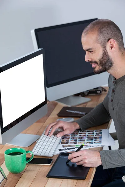 Fotógrafo masculino usando tableta gráfica en el escritorio —  Fotos de Stock