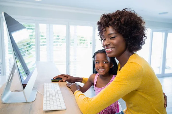 Madre e hija usando computadora en la sala de estar en casa —  Fotos de Stock