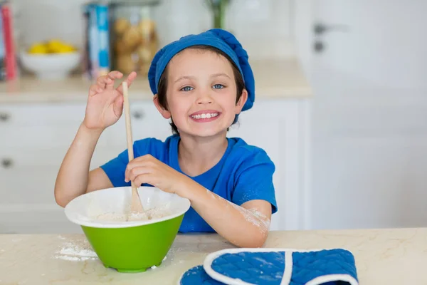 Sonriente chico mezclando masa de galletas en la cocina — Foto de Stock