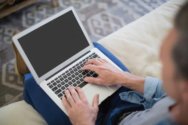 Mann benutzt Laptop im Wohnzimmer — Stockfoto