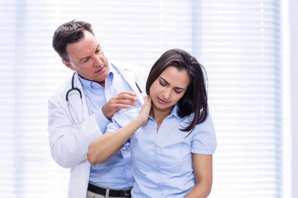 Paciente do sexo feminino mostrando dor no pescoço ao médico — Fotografia de Stock