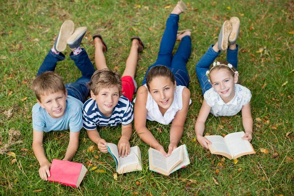 Dzieci leżąc na trawie i czytanie książek — Zdjęcie stockowe