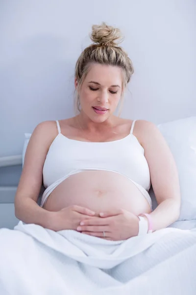 Mulher grávida relaxante na cama do hospital — Fotografia de Stock