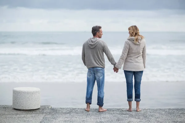 Couple debout avec la main sur la plage — Photo