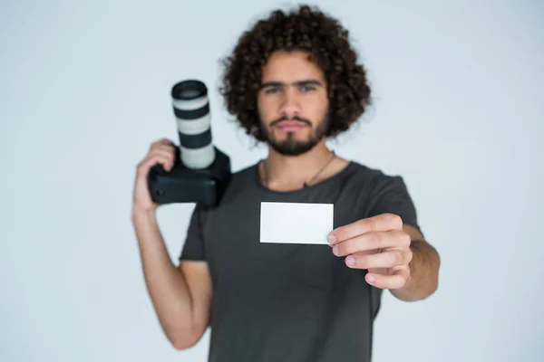 Fotograf zeigt Visitenkarte im Atelier — Stockfoto