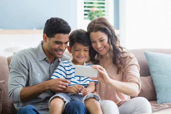 Parents and son checking photos in mobile phone — Stock Photo, Image