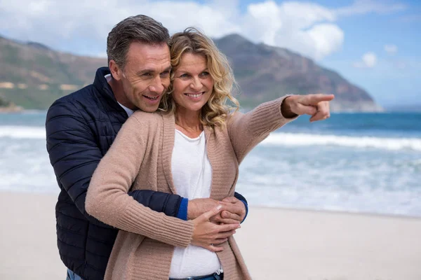 Ouder paar omhelzen elkaar op het strand — Stockfoto