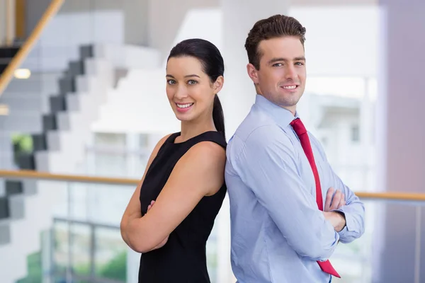 Confident business executives standing back to back with arms crossed — Stock Photo, Image