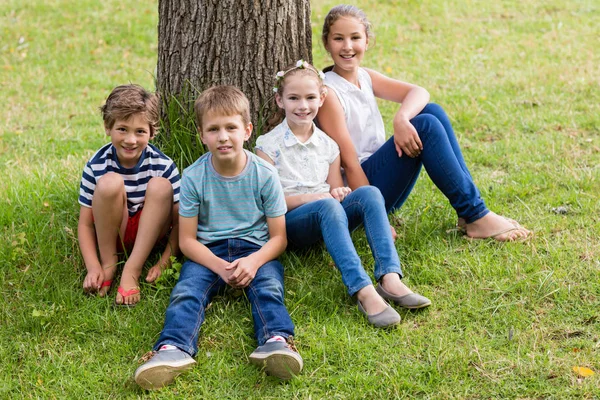 Smiling kids relaxing in park — Stock Photo, Image