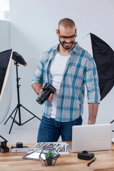 Photographe masculin examinant les photos capturées dans son appareil photo numérique — Photo