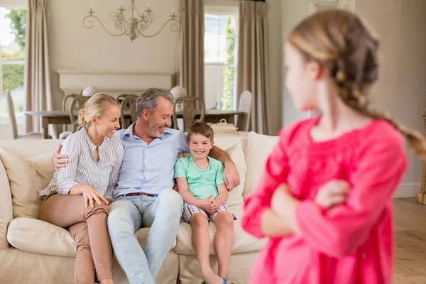 Flickan tittar tillbaka på familjen sitter på soffa — Stockfoto